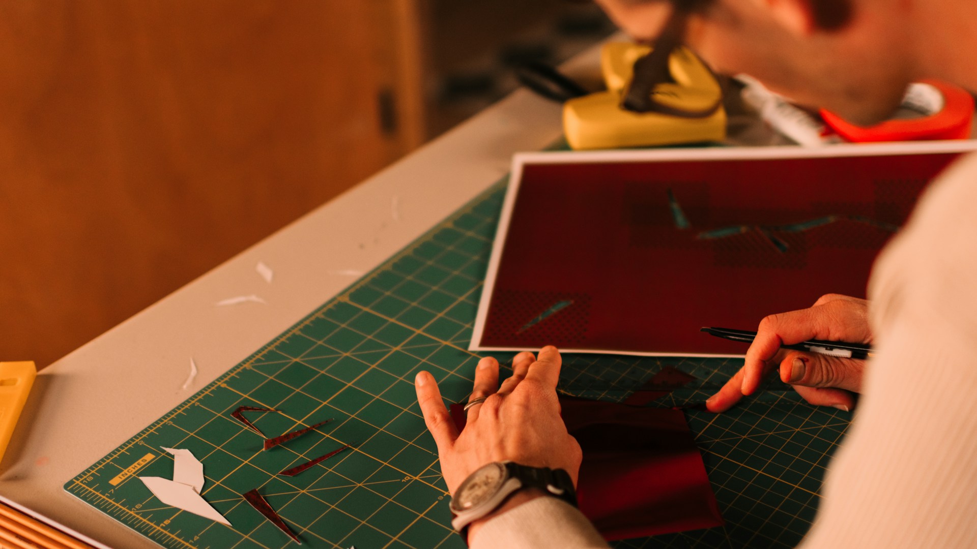 Person working on a craft project with paper and tools